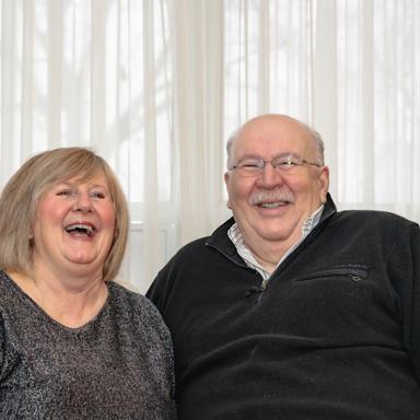 Elderly couple laughing together at home